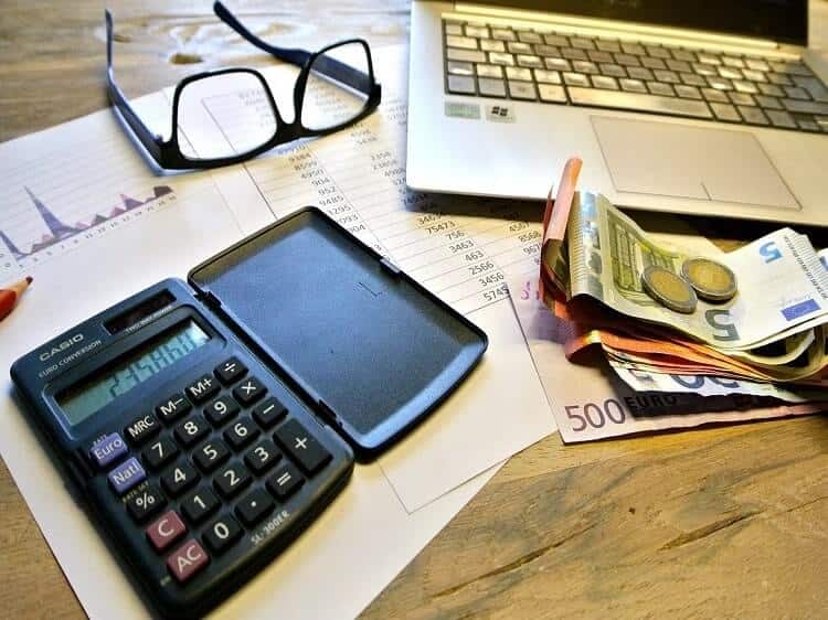 Afbeelding met een rekenmachine,geld en een laptop om een offerte aan te vragen