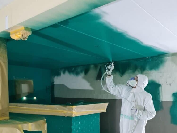 Schildersbedrijf tolkamer plafond spuiten in de kelder van een restaurant