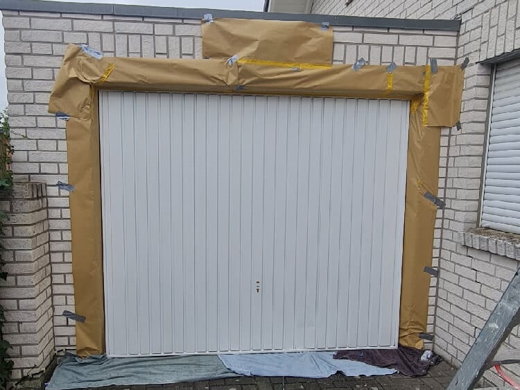 Schilderwerken garagedeur afgeplak voor spuiten